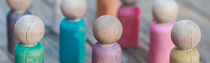 Bunte Holzspielfiguren in einer Gruppe